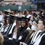 A graduate smiles for a photo during a graduation ceremony